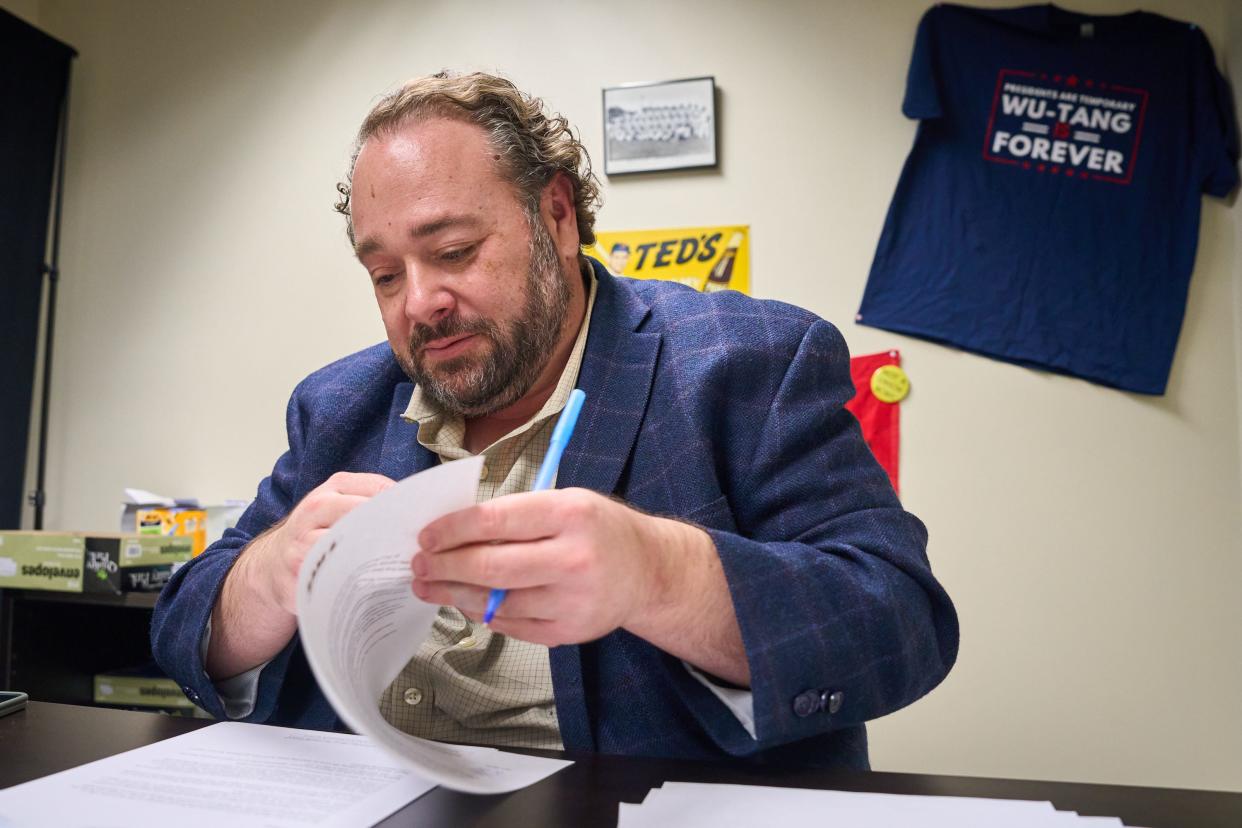 Sam Stone flips through a stack of letters as he signs each one on Jan. 12, 2023, before getting them ready to mail out as part of Stone’s campaign for the seat representing District 6 of Phoenix.