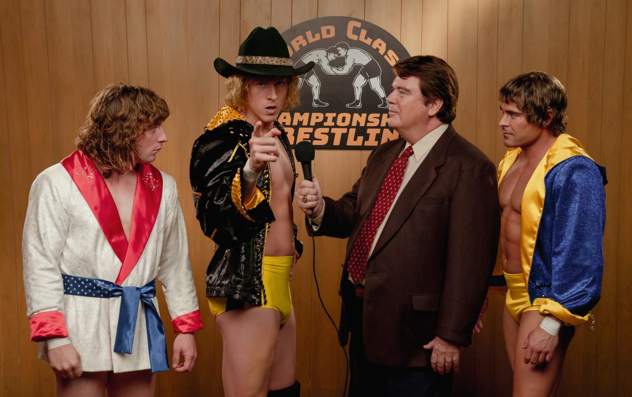 Bill Mercer (Michael Harney, second from right) interviews the wrestling trio of Kerry (Jeremy Allen White), David (Harris Dickinson) and Kevin Von Erich (Zac Efron) in "The Iron Claw."