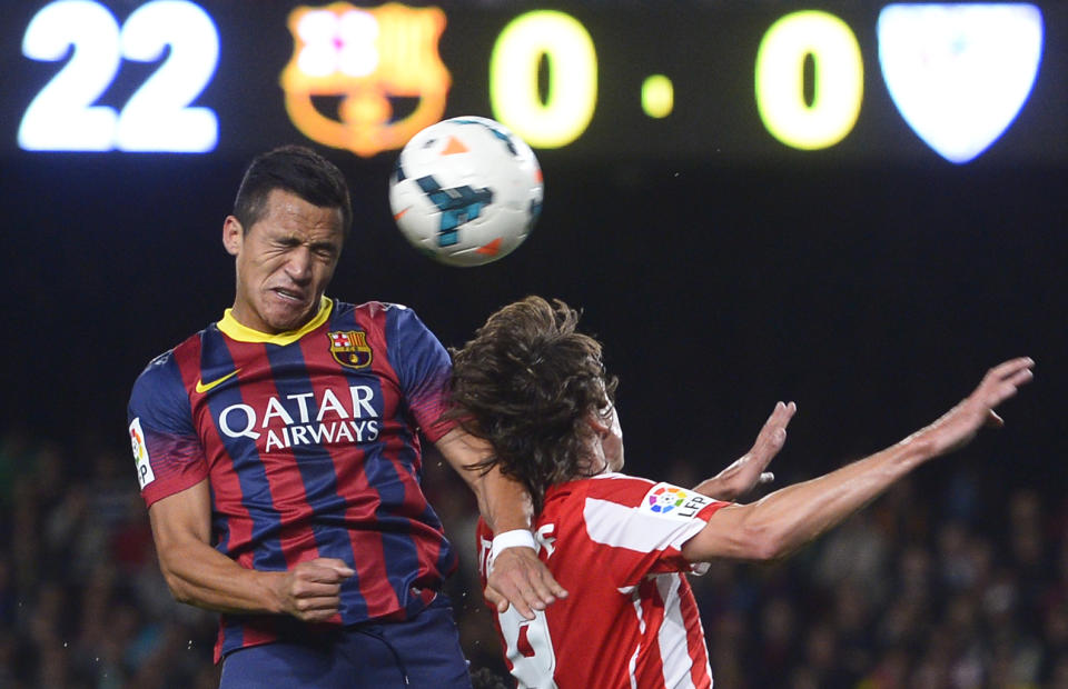 FC Barcelona's Alexis Sanchez, from Chile, left, duels for the ball against Athletic Bilbao's Ander Iturraspe during a Spanish La Liga soccer match at the Camp Nou stadium in Barcelona, Spain, Sunday, April 20, 2014. (AP Photo/Manu Fernandez)