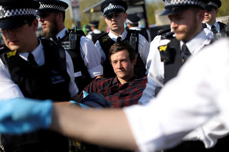 A climate change activist is detained during the Extinction Rebellion protest on Waterloo Bridge in London, Britain April 20, 2019. REUTERS/Simon Dawson