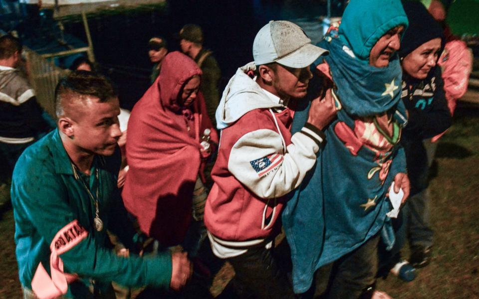 Survivors clad in blankets arrive onshore after being rescued from the tourist boat Almirante in the Reservoir of Penol in Guatape municipality in Antioquia on June 25, 2017 - Credit: JOAQUIN SARMIENTO/AFP