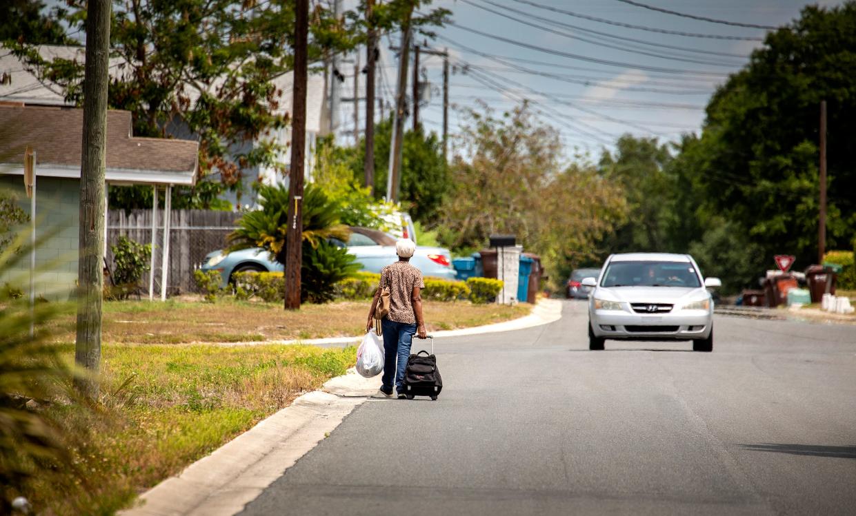 A woman walks along F Street in Lake Wales on a recent morning. The city has been awarded a Community Development Block Grant of $1.2 million that it plans to use for building and improving sidewalks in the Northwest Neighborhood.