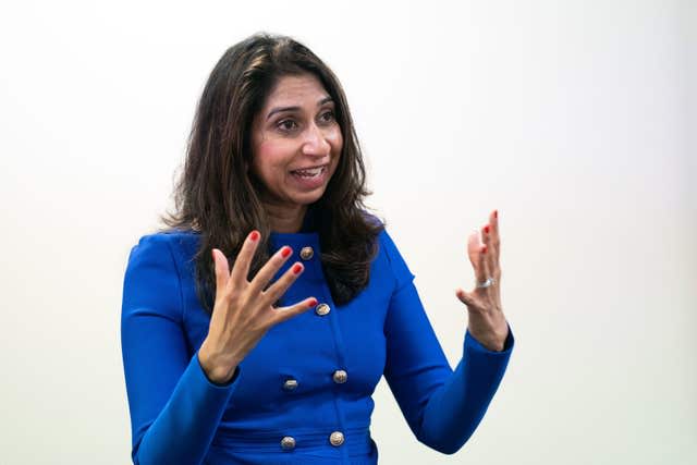 Suella Braverman gestures with her hands as she speaks, dressed in Conservative blue