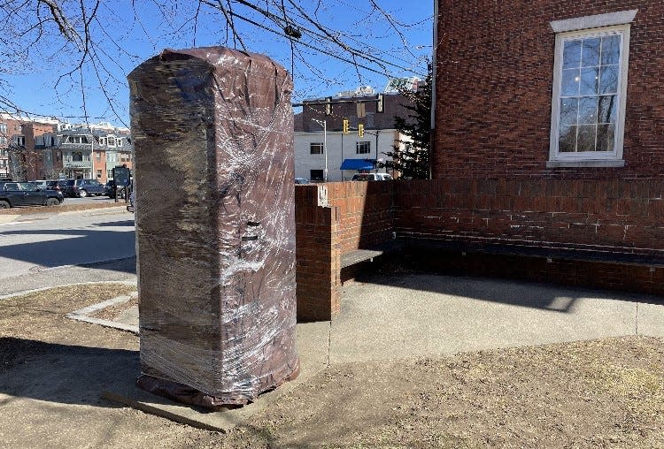 The phone booth outside the Portsmouth Historical Society, given to the city by Portsmouth, England, in 1984, is seen wrapped up Thursday, March 30, 2023, awaiting a project to repair it.