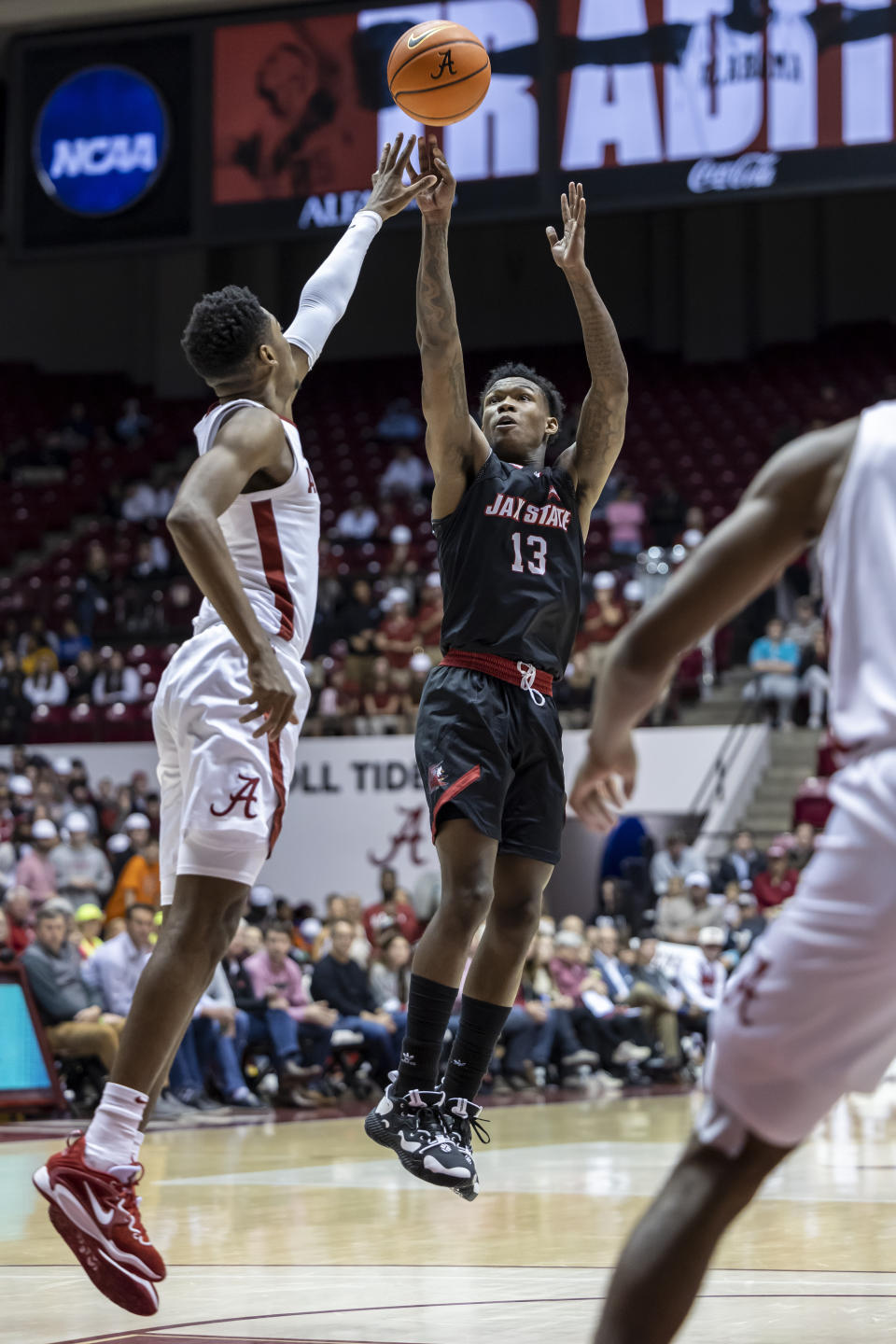 Jacksonville State guard Peyton Daniels (13) shoots a 3-point basket over Alabama forward Brandon Miller, left, during the first half of an NCAA college basketball game, Friday, Nov. 18, 2022, in Tuscaloosa, Ala. (AP Photo/Vasha Hunt)