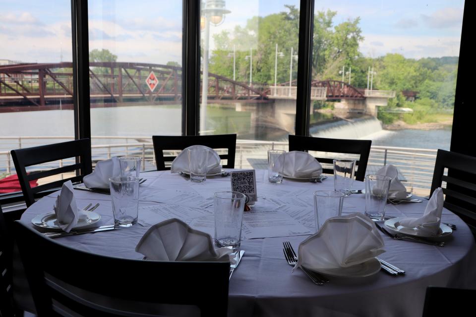 A fully set table overlooking the Iowa River awaits guests at the Iowa River Power Restaurant Friday, Aug. 4, 2023. The restaurant will close in November as the owner of the building, Randy Ward, will begin renovations and a search for a new tenant.