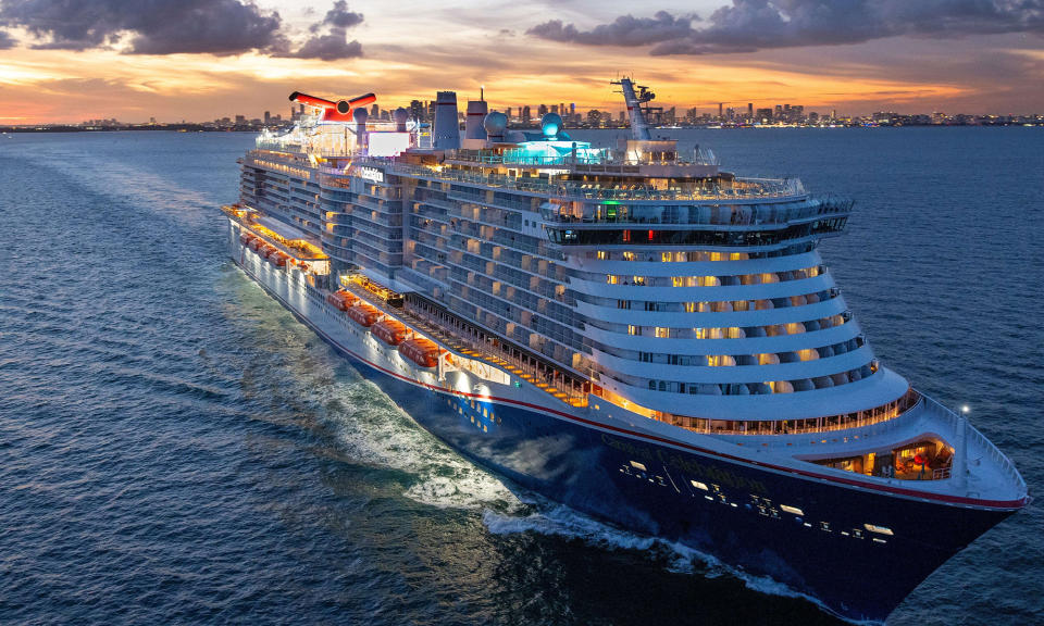 carnival cruise line ship at sunset with lights on_Carnival_Cruise_Lines_CCL