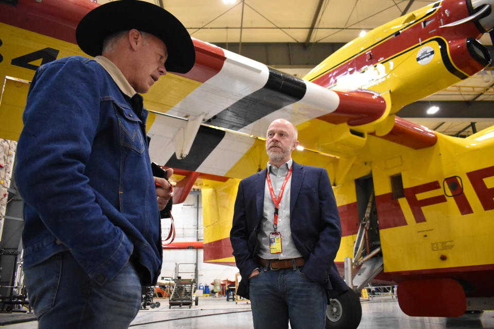 Republican U.S. House candidate Ryan Zinke, left, speaks with Darren Wilkins, an executive at Bridger Aerospace, in front a firefighting aircraft inside a hangar at Bozeman Yellowstone International Airport, Oct. 27, 2022, in Belgrade, Mont. Zinke is challenged by a well-financed Democrat on the left, a determined Libertarian on the right, and by his own reputation among Montana voters. (AP Photo/Matthew Brown)