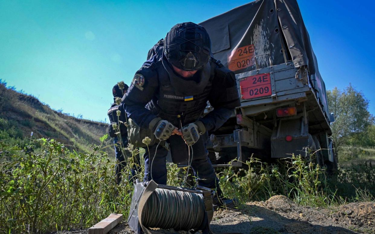 A member of State Emergency Service of Ukraine prepares to detonate found munitions from World War II near the Kharkiv region