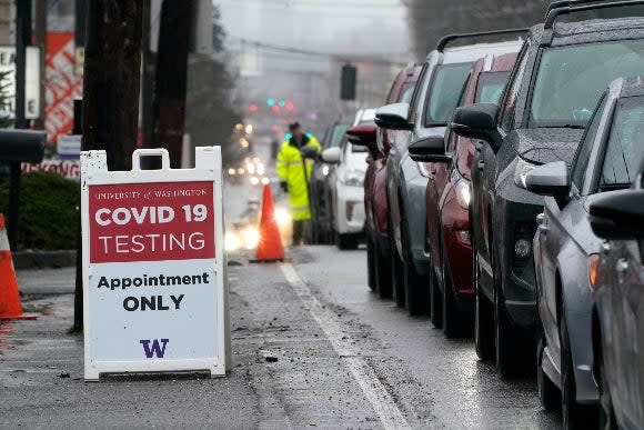 A line of cars stretching several blocks wait to pull into an appointment-only COVID-19 testing center, Thursday, Jan. 6, 2022, in Seattle