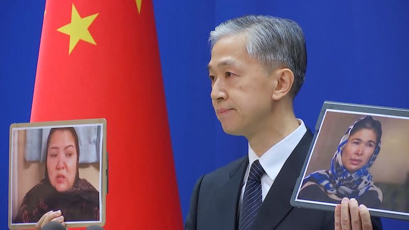 FILE PHOTO: Chinese Foreign Ministry spokesman Wang Wenbin holds pictures while speaking during a news conference in Beijing