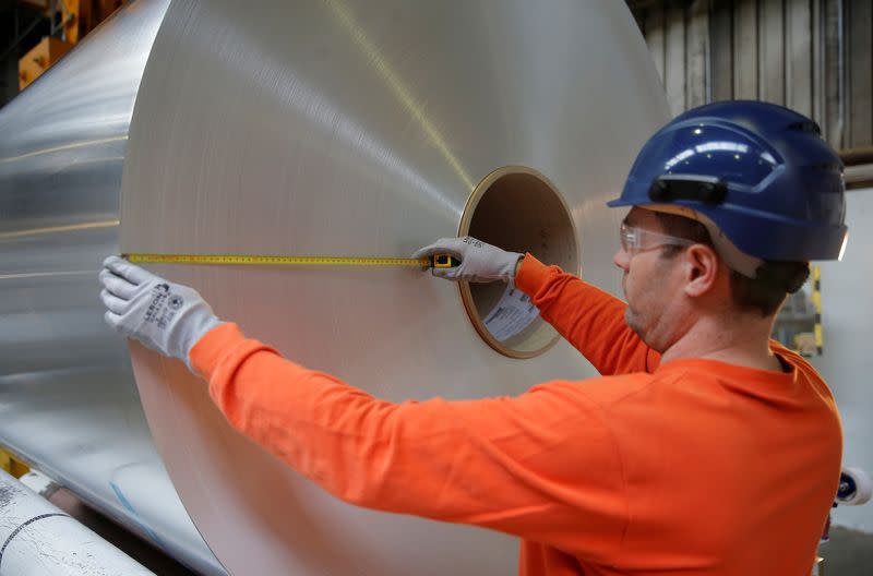 A worker measures the diameter of a coil of aluminium at the Neuf-Brisach Constellium aluminium products company's production unit in Biesheim