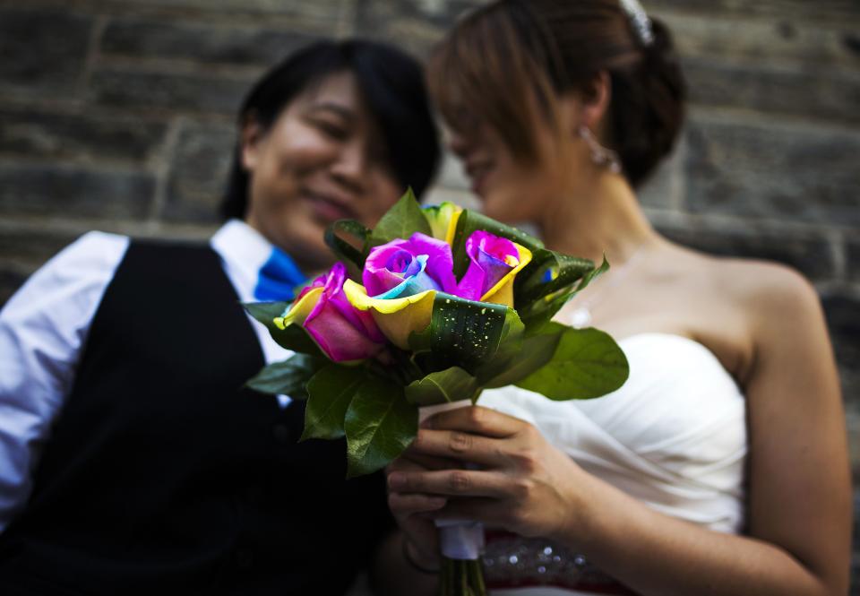 Lee and Chang Ho hold a rainbow-coloured bouquet of flowers, before they take part in the "Celebration of Love", a grand wedding where over 100 LGBT couples got married, at Casa Loma in Toronto