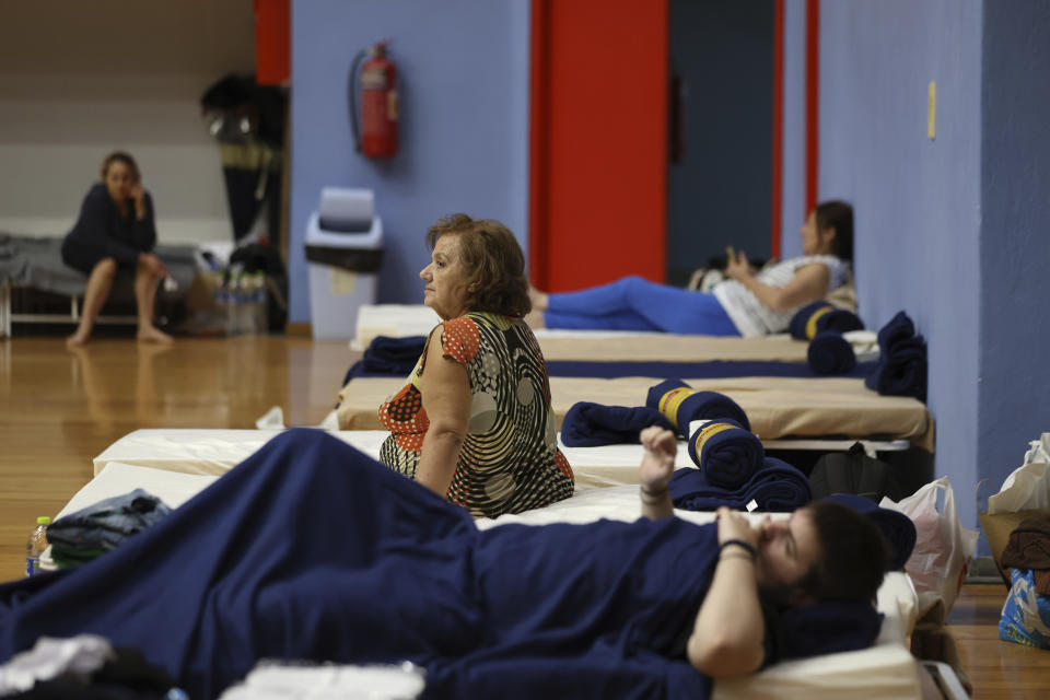 People rest at an indoor sport center in Larissa, Thessaly region, central Greece, Thursday, Sept. 7, 2023, after the country's record rainstorm. Widespread flooding in central Greece has left at least four people dead and six missing, with severe rainstorms turning streams into raging torrents, bursting dams, washing away roads and bridges, and hurling cars into the sea. (AP Photo/Vaggelis Kousioras)