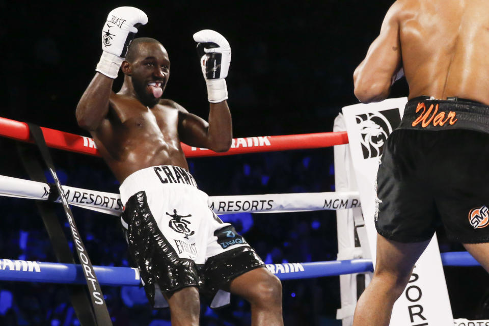 Terence Crawford, left, reacts against the ropes while fighting Shawn Porter during a welterweight title boxing match Saturday, Nov. 20, 2021, in Las Vegas. (AP Photo/Chase Stevens)