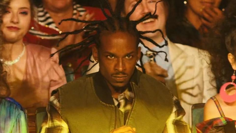 An actor playing Coolio in the audience in Weird