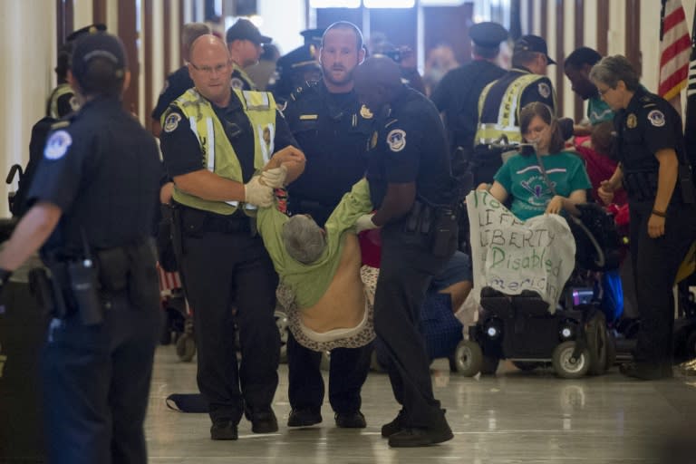US Capitol Police arrest a protestor against the Senate Republican's draft healthcare bill outside the office of Senate Majority Leader Mitch McConnell, Republican of Kentucky, on Capitol Hill in Washington, DC, June 22, 2017