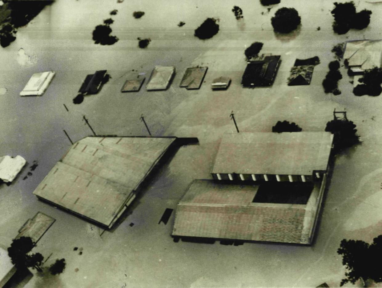 Flood waters swirl around industrial buildings and houses in the outer Brisbane suburb of Gailes, in 1974