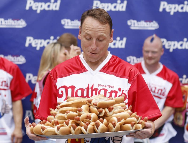 Joey Chestnut holds a tray of hot dogs at the 107th Nathan's Famous Fourth of July International Hot Dog Eating Contest weigh-in ceremony on July 3 in New York City. The competitive eater turns 40 on November 25. File Photo by John Angelillo/UPI