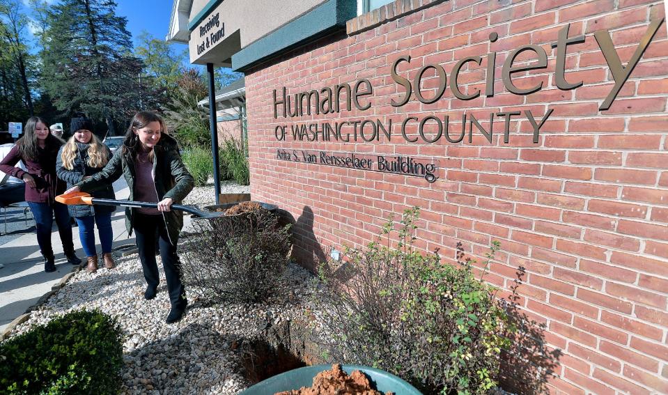 Colin Berry, executive director for the Humane Society of Washington County, throws the first shovel of dirt to bury a time capsule of memorabilia outside HSWC building on Maugansville Road as part of HSWC's 100th anniversary celebration. 