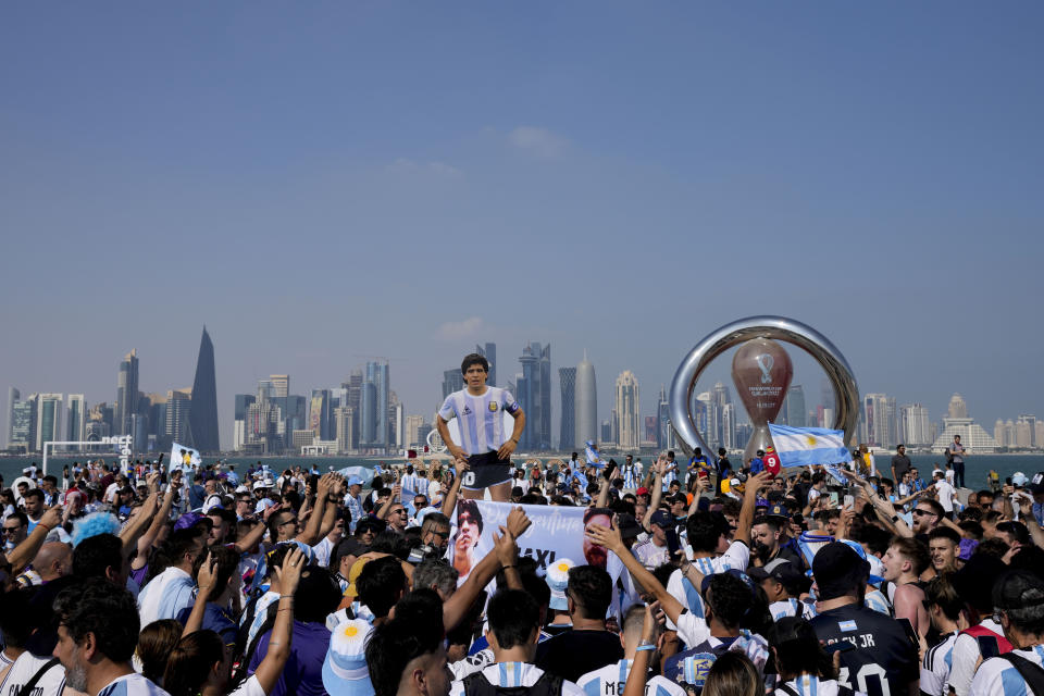 Aficionados de Argentina, con una imagen a tamaño real del as Diego Maradona, se reúnen en la víspera del debut de su selección en el Grupo C del Mundial de Qatar, frente a Arabia Saudí, en Doha, Qatar, el 21 de noviembre de 2022. (AP Foto/Jorge Sáenz)