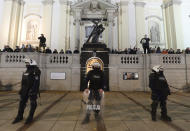 Members of a far-right organization stand guard in front of the Holy Cross Church, fronted by a row of police officers, in Warsaw, Poland, Wednesday Oct. 28, 2020. The far-right group members vowed to defend churches after protesters angry over an abortion ban disrupted Masses and spray-painted churches last Sunday. (AP Photo/Czarek Sokolowski)