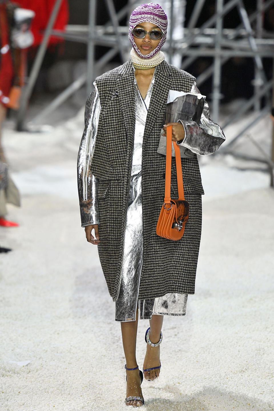 <p>A model wears a balaclava and a houndstooth sleeveless coat over a metallic-silver coat at the Calvin Klein fall 2018 show. (Photo: Getty Images) </p>