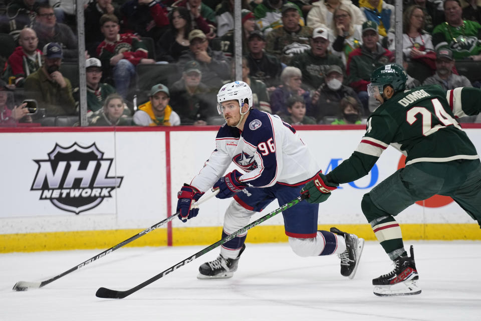 Columbus Blue Jackets center Jack Roslovic (96) skates with the puck against Minnesota Wild defenseman Matt Dumba (24) during the second period of an NHL hockey game Sunday, Feb. 26, 2023, in St. Paul, Minn. (AP Photo/Abbie Parr)