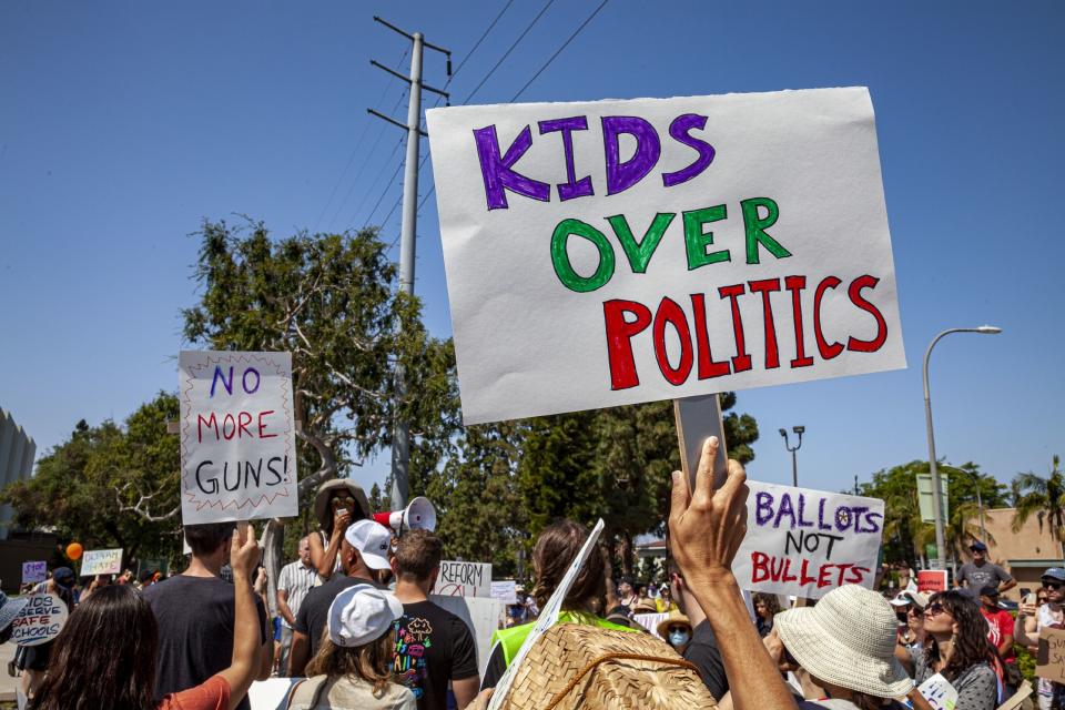 People hold signs to protest gun violence in schools