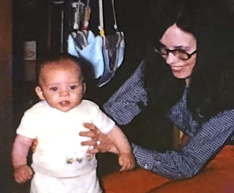 A woman helps a baby stand in this image from an 8 mm film Leah Tribbett found in an antique store.