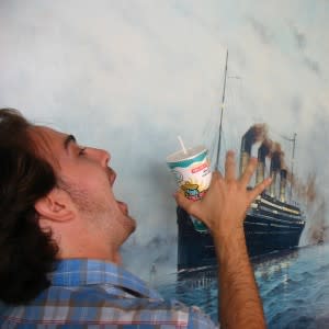 Man drinking in front of yacht