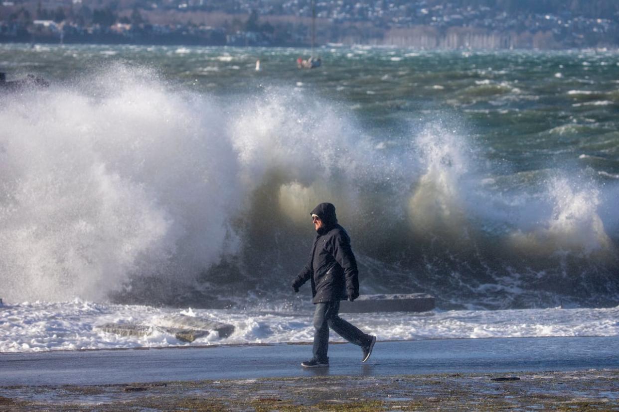 Waves are pictured crashing into the seawall in English Bay during a king tide in Vancouver in January 2022. On Thursday morning, a king tide and storm surge are expected to produce large waves that could lead to coastal flooding along Metro Vancouver shorelines. (Ben Nelms/CBC - image credit)