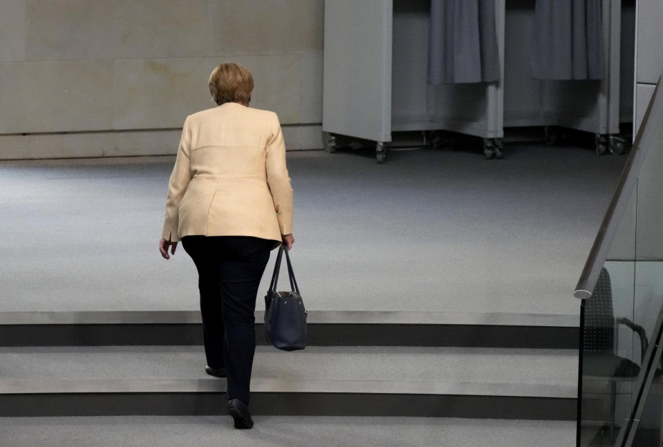 File - In this Tuesday, Sept. 7, 2021 file photo, German Chancellor Angela Merkel leaves the plenary hall after a debate about the situation in Germany ahead of the upcoming national election in Berlin, Germany. Angela Merkel, Germany's first female chancellor, has been praised by many for her pragmatic leadership in a turbulent world and celebrated by some as a feminist icon but she wouldn't seek reelection in the country's Sept. 26 general election. (AP Photo/Markus Schreiber, File)