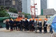 Singaporean rescuers gather outside the Downtown Line (DTL) Bugis Station subway construction site in Singapore on July 18, 2012. Two workers were killed and eight others injured in Singapore when the scaffolding at a subway construction site collapsed on Wednesday, civil defence officials said