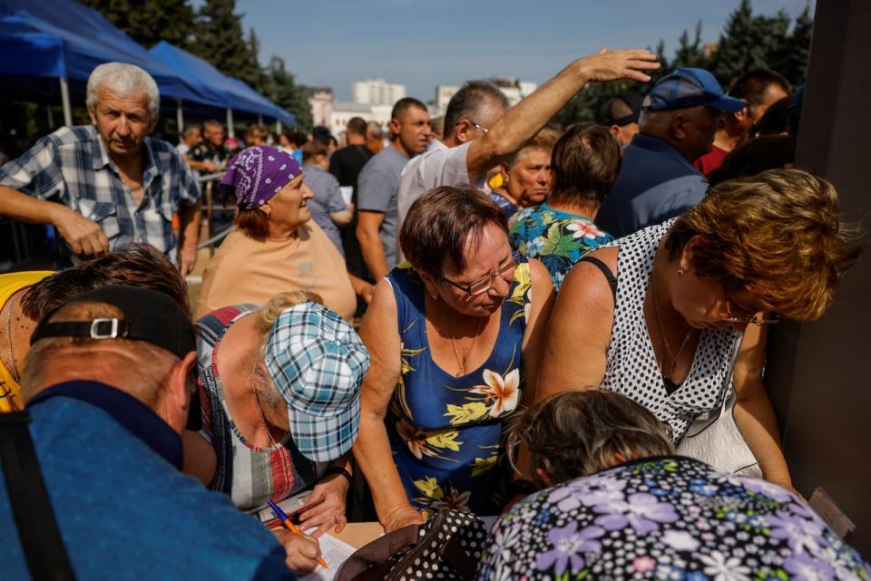 People queue at a humanitarian aid distribution center for residents, who were evacuated from the Kursk region.