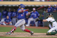 Toronto Blue Jays' Alejandro Kirk, left, hits an RBI single in front of Oakland Athletics catcher Sean Murphy during the fourth inning of a baseball game in Oakland, Calif., Monday, July 4, 2022. (AP Photo/Jeff Chiu)