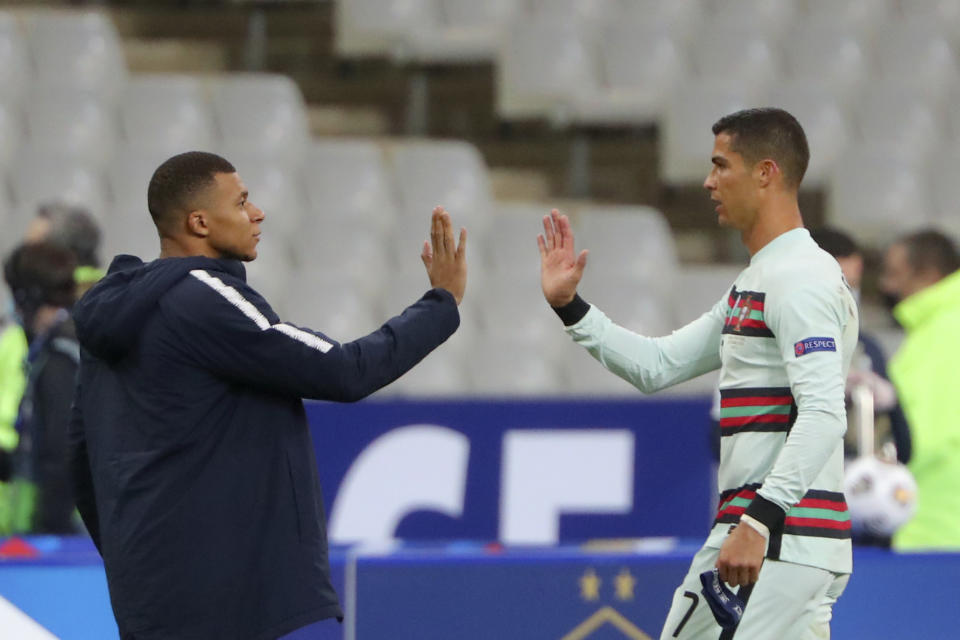 ARCHIVO - En esta foto del domingo 11 de octubre de 2020, el francés Kylian Mbappé y el portugués Cristiano Ronaldo se saludan previo a un partido amistoso en el Stade de France en Saint-Denis, norte de París. El domingo 25 de octubre del 2020 el enfrentamiento entre Cristiano Ronaldo y Lionel Messi podría no ocurrir debido a que el portugués no ha aparecido con su equipo tras dar positivo por COVID-19. (AP Foto/Thibault Camus, archivo)