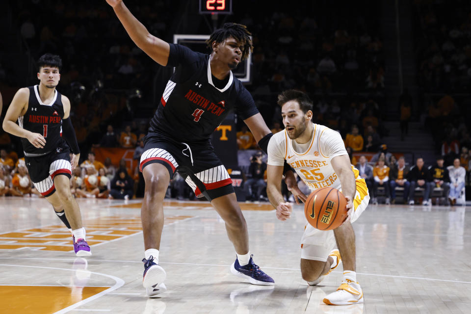 Tennessee guard Santiago Vescovi (25) passes the ball around Austin Peay center Elijah Hutchins-Everett (4) during the first half of an NCAA college basketball game Wednesday, Dec. 21, 2022, in Knoxville, Tenn. (AP Photo/Wade Payne)