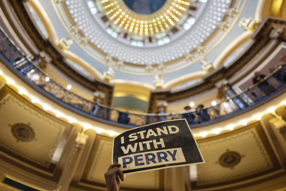 A student holds up a sign that reads "I Stand With Perry" at a gun violence protest in the rotunda during the opening day of the Iowa Legislature, Monday, Jan. 8, 2024, at the Capitol in Des Moines, Iowa. The school walkout and protest were organized by March For Our Lives Iowa in reaction to a school shooting in Perry, Iowa, in which a 17-year-old killed a sixth-grade student and wounded seven other people before authorities say he died of a self-inflicted gunshot wound. (AP Photo/Carolyn Kaster)