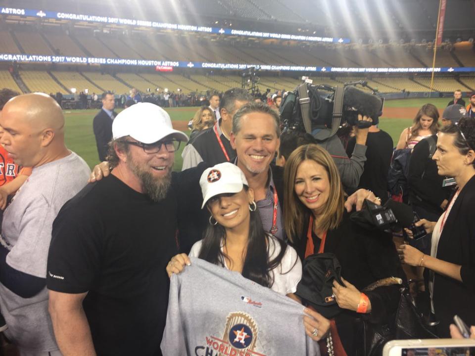 Jeff Bagwell and Craig Biggio pose on the field with their wives after the Astros win Game 7 of the 2017 World Series. (Twitter/@alysonfooter)