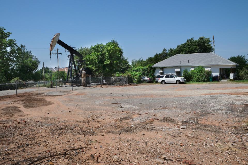 A home sits next door to an oil pump jack along NE 8.