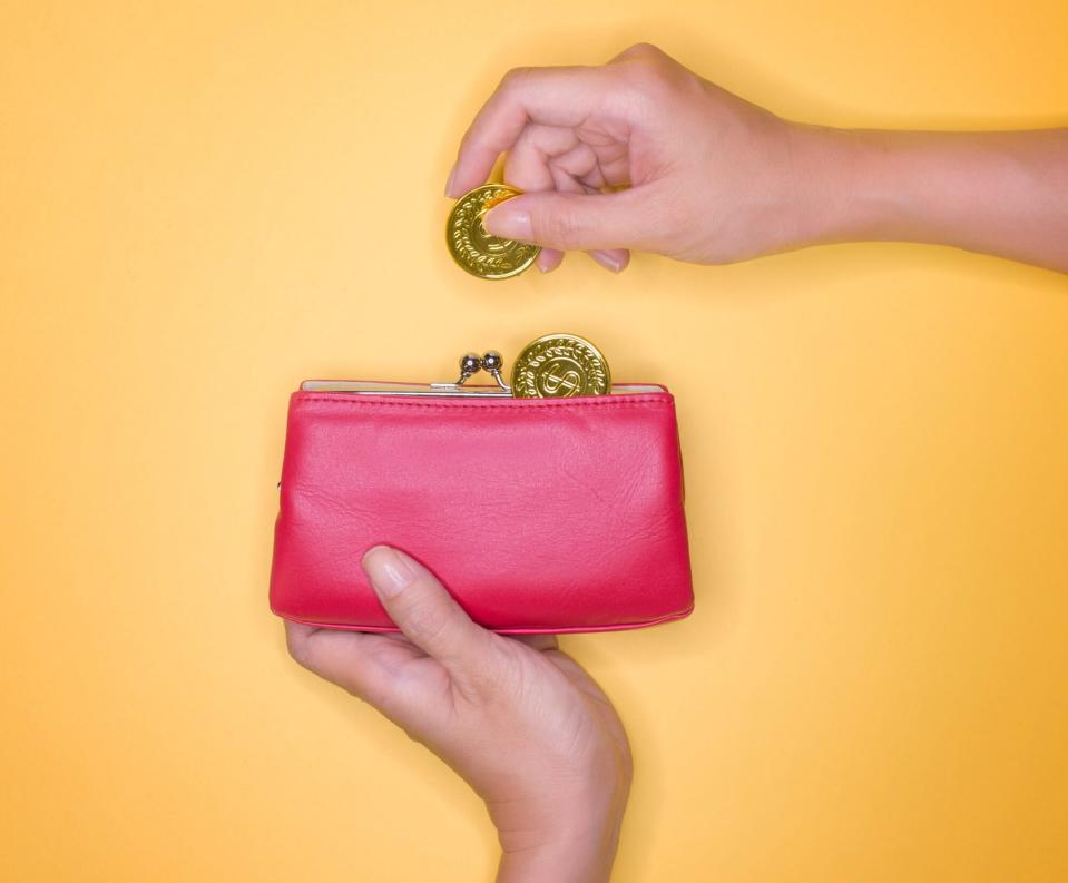 An image of a woman holding a change purse.