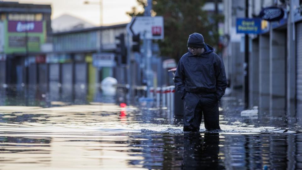 A man walks through flood water up to his knees on Downpatrick's main shopping street