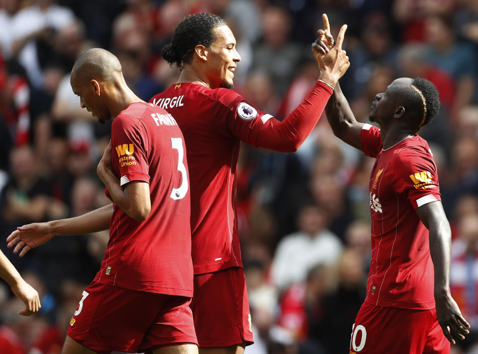 Liverpool's Sadio Mane, right, celebrates with Liverpool's Virgil van Dijk, center, and Liverpool's Fabinho, right, after scoring his sides second goal during the English Premier League soccer match between Liverpool and Newcastle at Anfield stadium in Liverpool, England, Saturday, Sept. 14, 2019. (AP Photo/Rui Vieira)