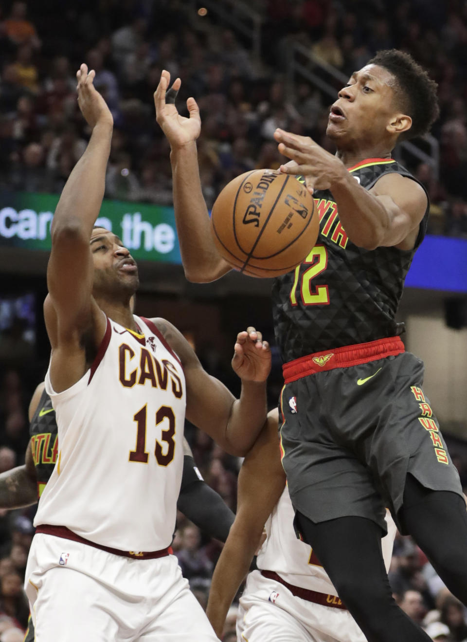 Atlanta Hawks' De'Andre Hunter (12) loses control of the ball as Cleveland Cavaliers' Tristan Thompson (13) defends during the second half of an NBA basketball game Monday, Dec. 23, 2019, in Cleveland. The Cavaliers won 121-118. (AP Photo/Tony Dejak)