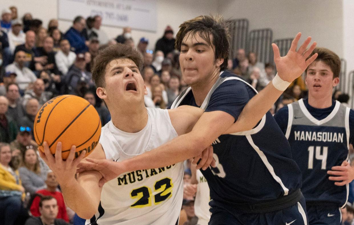 Marlboro Jack Seidler (No. 22, left) drives to the basket as he's guarded by Manasquan Alex Konov (No. 23, center) as Manasquan's Griffin Linstra (No. 14) watches. Marlboro Boys Basketball defeats Manasquan 63-46 in Shore Conference Finals in Toms River on February 27, 2022.