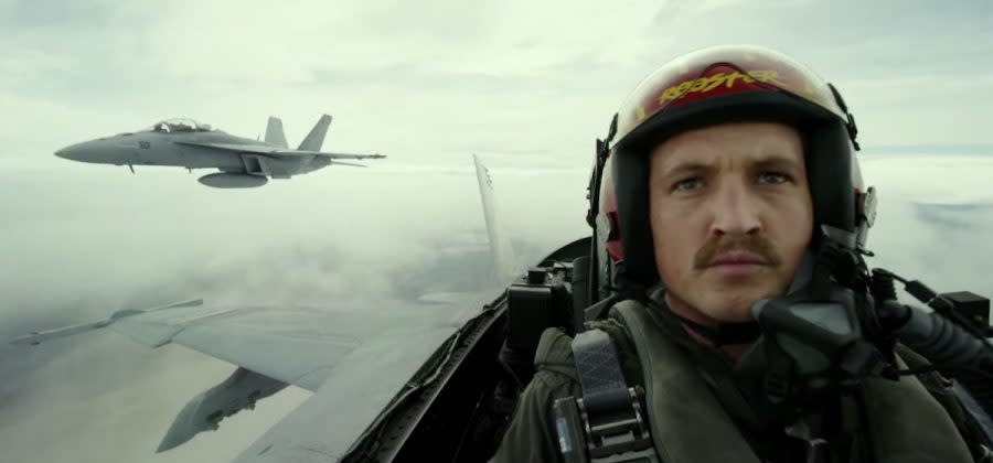 Miles Teller's Rooster flying a fighter jet with anothe rplane behind him