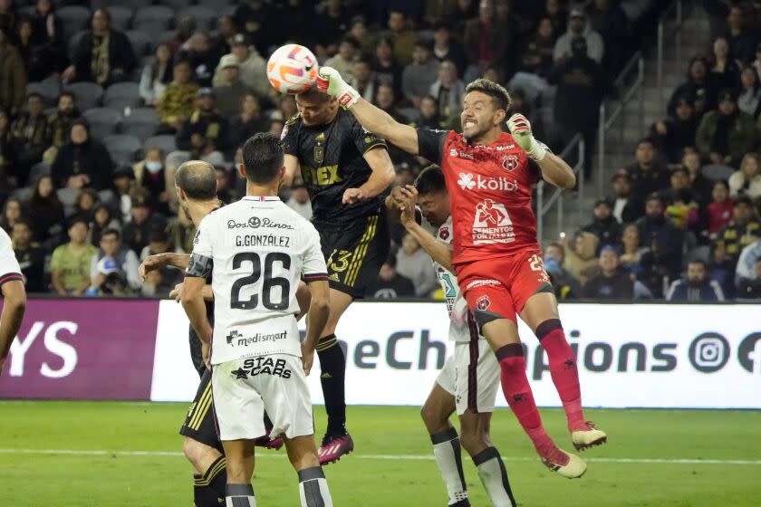 Alajuelense goalkeeper Leonel Moreira, right, punches the ball as Los Angeles FC's Aaron Long, top center, attempts a header on a corner kick during the first half of a CONCACAF Champions League soccer match Wednesday, March 15, 2023, in Los Angeles. (AP Photo/Marcio Jose Sanchez)
