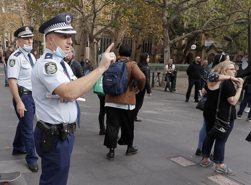 A police officer counts protesters as they gather in Sydney, Saturday, June 13, 2020, during a day of demonstrations across Australia in support of the Black Lives Matter movement and refugee rights. Protesters in Sydney, Adelaide and Perth were urged to stay away by government officials concerned about the risk of spreading the new coronavirus. (AP Photo/Rick Rycroft)