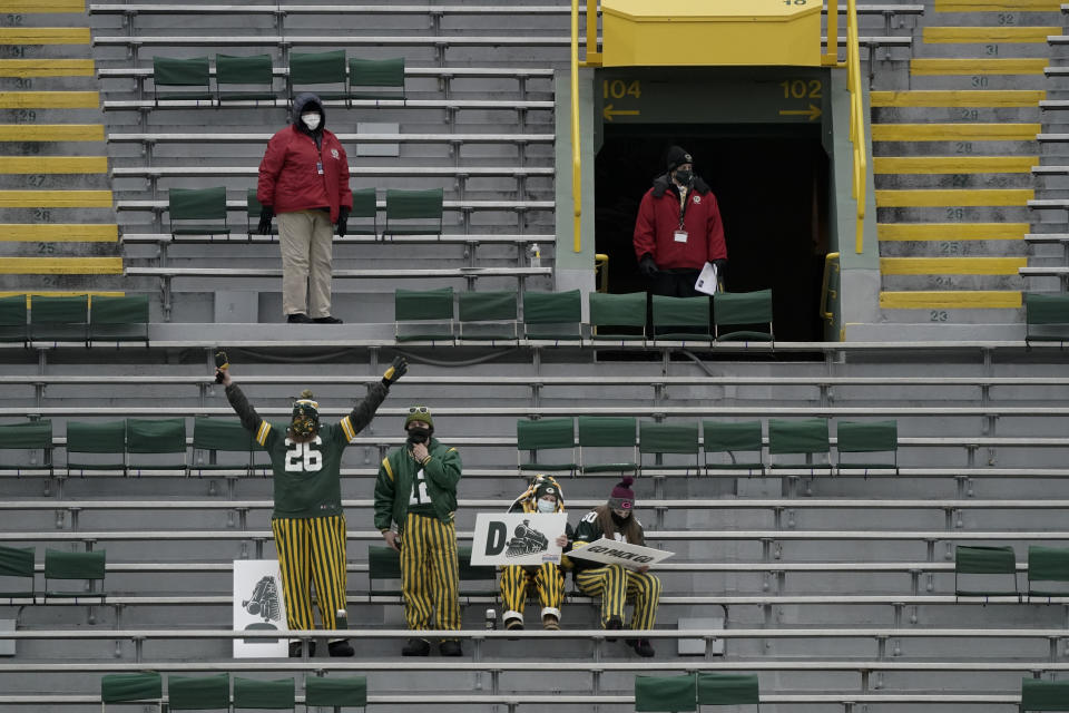 Fans take their socially distanced seats in Lambeau Field before an NFL divisional playoff football game between the Los Angeles Rams and Green Bay Packers, Saturday, Jan. 16, 2021, in Green Bay, Wis. (AP Photo/Morry Gash)
